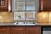 Kitchen featuring sink, stainless steel dishwasher, and tasteful backsplash