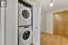 Laundry room with stacked washer / dryer and light tile patterned flooring