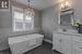 Bathroom featuring tile walls, a bath, vanity, and tile patterned flooring