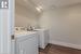 Laundry area with dark wood-type flooring and washer and dryer