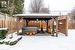 Snow covered patio with a hot tub and a gazebo