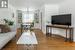 Living room featuring hardwood / wood-style flooring, crown molding, built in shelves, and a textured ceiling