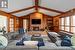 Great room featuring vaulted ceiling with beams, hardwood floor, wood burning fireplace and wood walls