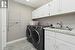 Main level laundry with cabinets, washer and dryer, sink and broom closet