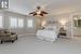 Bedroom featuring ensuite bathroom, ceiling fan, and carpet flooring