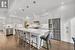 Kitchen with a kitchen island, stainless steel appliances, decorative light fixtures, and white cabinets