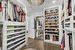 Walk in closet with dark wood-type flooring and an inviting chandelier