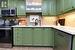 Kitchen featuring green cabinets, stainless steel appliances, a sink, and light countertops