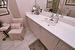 Bathroom with marble finish floor, a shower with door, toilet, vanity, and baseboards