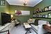 Living area featuring light carpet, ornamental molding, a chandelier, and baseboards