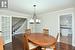 Dining room featuring ornamental molding, a notable chandelier, dark wood finished floors, and stairs