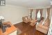 Living area with dark wood-style floors, ornamental molding, a textured ceiling, and baseboards