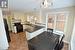 Kitchen with white cabinets, hanging light fixtures, a sink, and black appliances