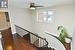 Stairs featuring a textured ceiling, wood finished floors, a ceiling fan, and baseboards