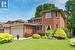 View of front of property with a front lawn, brick siding, and an attached garage