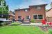 Back of property featuring a hot tub, fence, a pergola, and brick siding