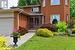 View of exterior entry featuring a garage, a yard, and brick siding