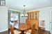 Dining room with crown molding, dark wood-style flooring, baseboards, and a notable chandelier