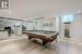 Sprawling Recreation Room with a Wet Bar and Distinctive Ceiling Accents
