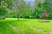 Beautifully Maintained One Acre, Tree-Lined Property with Gorgeous Flower Beds