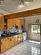 Kitchen with decorative backsplash, light tile patterned floors, ceiling fan, and white electric range oven