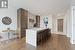 Kitchen featuring a kitchen island with sink, light wood-type flooring, sink, and a breakfast bar