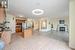 Kitchen with a kitchen bar, backsplash, stainless steel appliances, light tile patterned floors, and decorative light fixtures