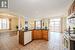 Kitchen featuring pendant lighting, dishwasher, sink, light hardwood / wood-style flooring, and ornate columns