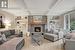 Living room with crown molding, built in features, beamed ceiling, and a brick fireplace