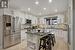 Kitchen featuring a center island, sink, stainless steel appliances, and white cabinets