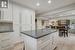 Kitchen with dark stone countertops, white cabinetry, a fireplace, and light parquet flooring