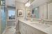 Bathroom featuring tile patterned flooring, vanity, toilet, and a shower with door