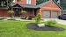 View of front of property with a garage and a front lawn