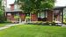 View of front of property with covered porch and a front lawn