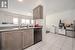 Kitchen with sink, light tile patterned floors, and black appliances