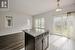 Kitchen featuring hanging light fixtures, light stone countertops, and a center island