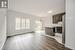 Kitchen with pendant lighting, stainless steel fridge, decorative backsplash, a center island, and dark brown cabinets