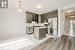 Kitchen featuring hanging light fixtures, dark brown cabinets, stainless steel appliances, and a kitchen island