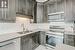 Kitchen with sink, stainless steel appliances, light stone countertops, light tile patterned flooring, and decorative backsplash