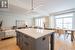 Kitchen featuring light hardwood flooring, a kitchen breakfast bar, a center island, and gray cabinets