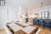 Kitchen featuring light hardwood flooring, decorative light fixtures, a kitchen island, white cabinets, and appliances with stainless steel finishes