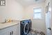 Washroom with sink, light tile patterned flooring, separate washer and dryer, and cabinets