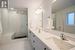 Principle Bathroom featuring large vanity with quartz counter tops and walk in shower with glass front