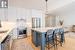 Kitchen featuring hanging light fixtures, a center island, stainless steel appliances, a breakfast bar, and white cabinetry