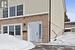 Snow covered property entrance with brick siding