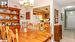 Carpeted dining area featuring ceiling fan with notable chandelier and crown molding