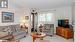 Carpeted living room featuring an AC wall unit and ornamental molding