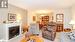 Living room featuring a fireplace, light colored carpet, and an inviting chandelier