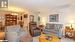 Living room featuring a wall mounted AC, a chandelier, crown molding, and light tile patterned flooring