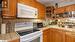 Kitchen with white appliances, tile countertops, and backsplash